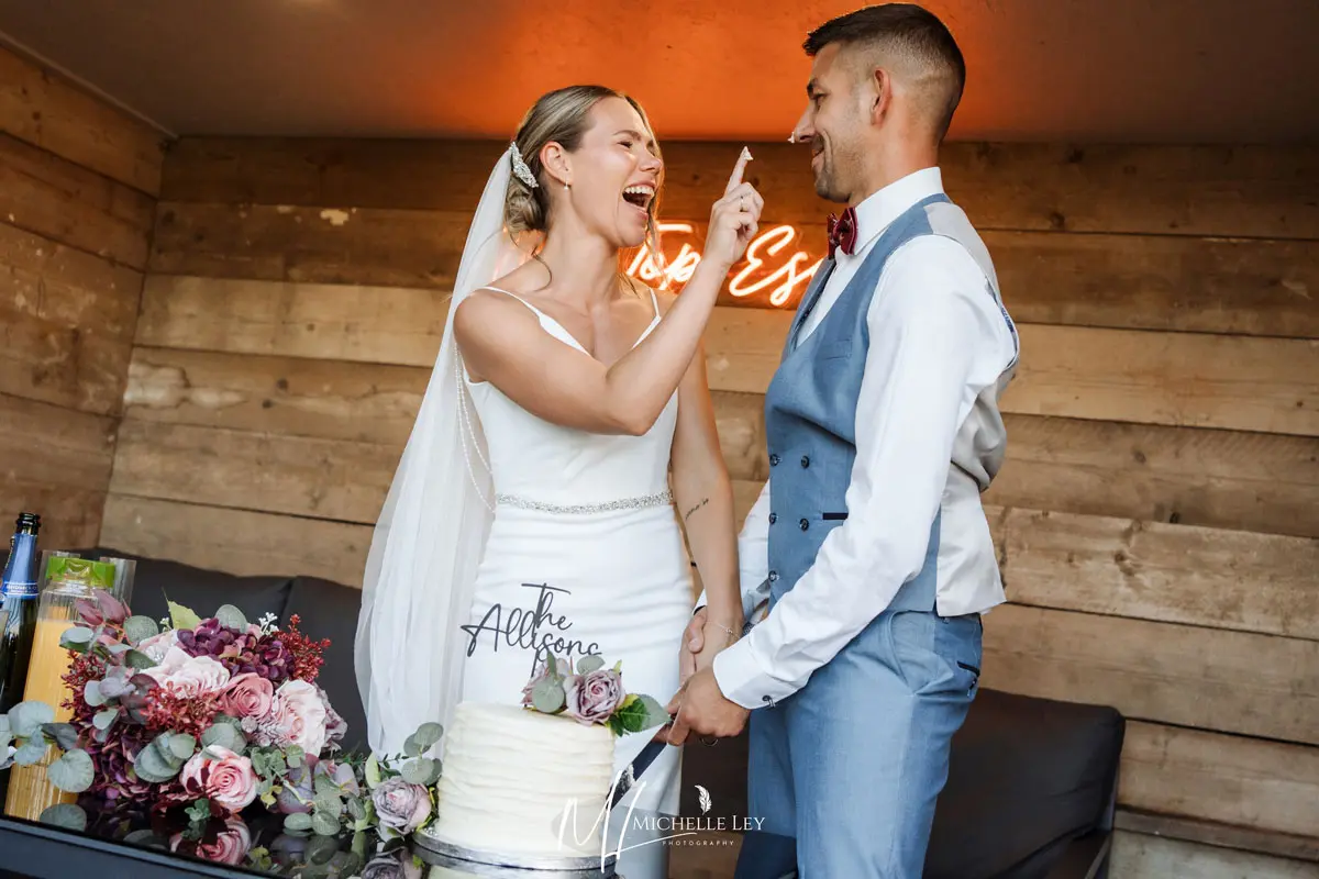 a romantic couple who have just cut their wedding cake at tree top escape intimate wedding venue in devon