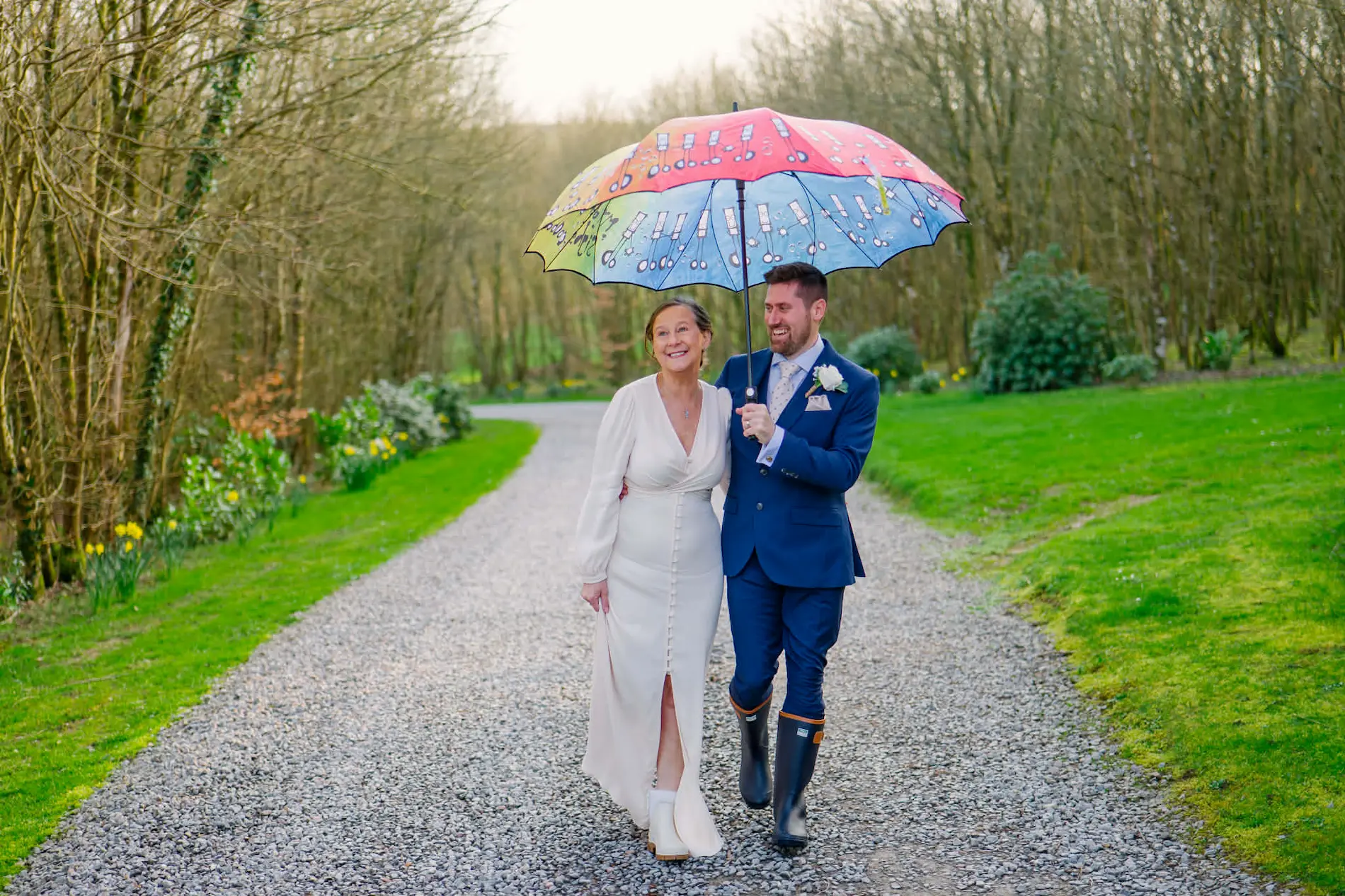 Sarah and Chris by the lake at Tree Top Escape in their wedding wellies